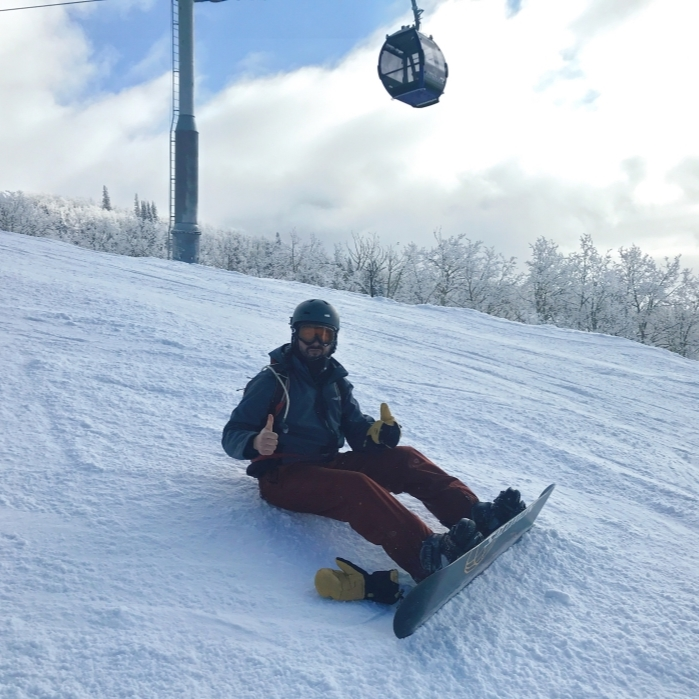 Person on snowboard holding thumbs up