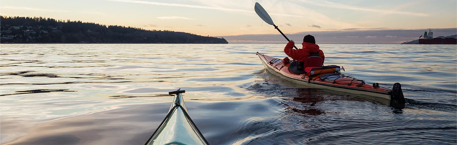 The back of a kayaker at sea.