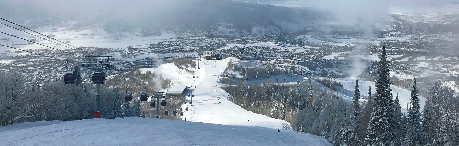 A snowy mountain at a ski resort with ski lifts