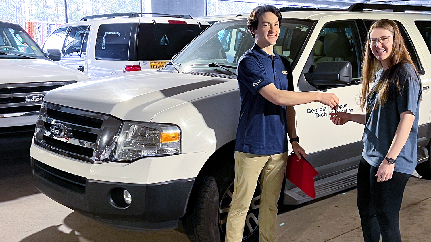 A CRC student sfaff hands the keys of a rental vehicle to a female student.